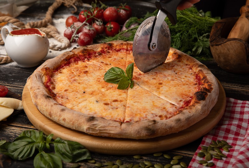 najpopularniejsze dania włoskie, jak pokrojona pizza Margherita najpopularniejsze dania włoskie, czyli pizza Margherita na desce