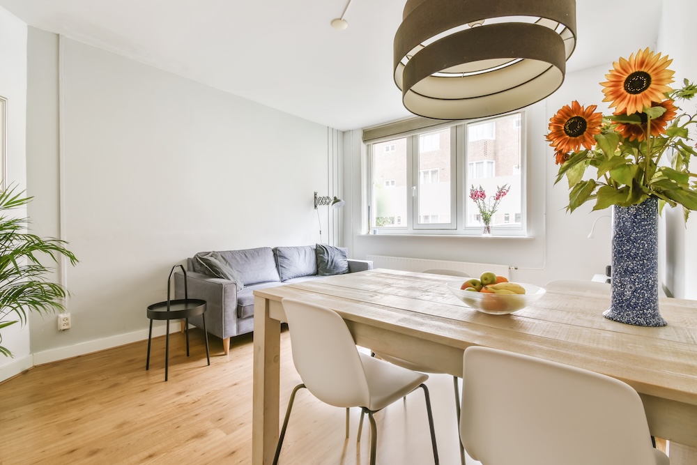 aranżacje salonu z jadalnią z drewnianym stołem i dwoma białymi krzesłami 