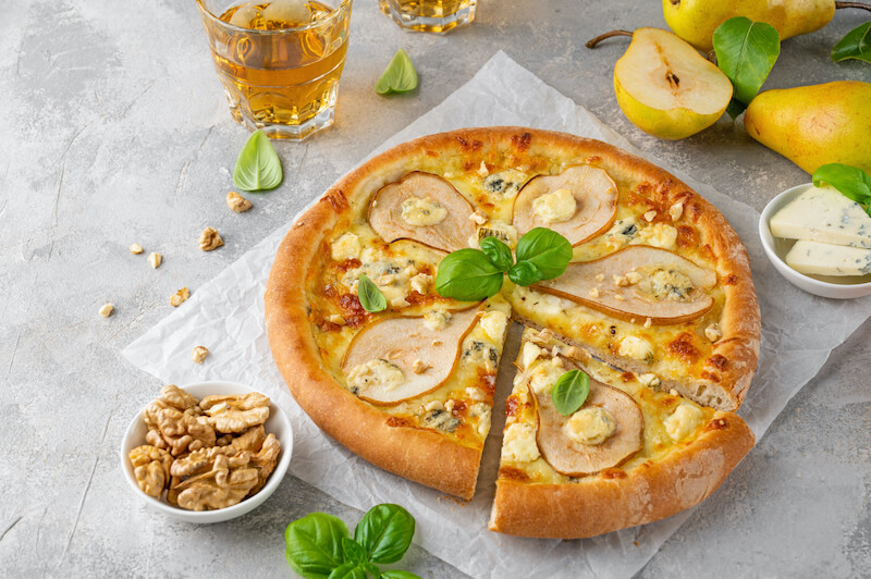 pokrojona pizza z gruszką na szarym tle pizza z gruszką i orzechami