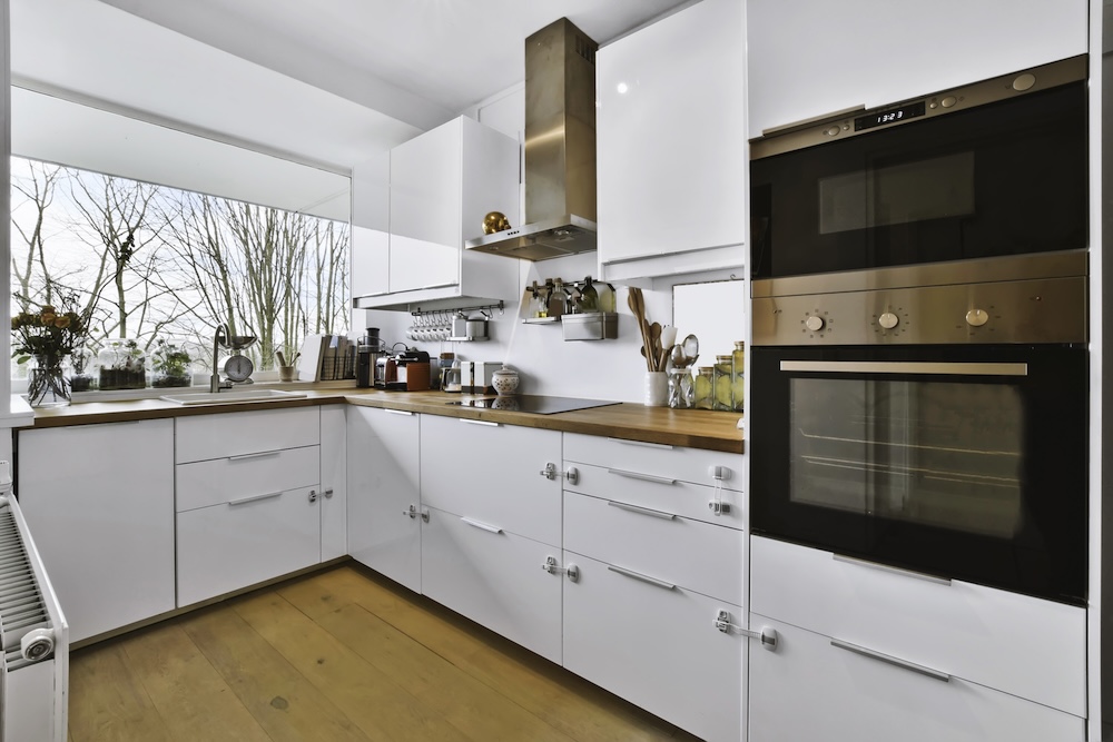 kuchnia z białymi szafkami i drewnianym blatem  mała kuchnia z dużym oknem nad blatem