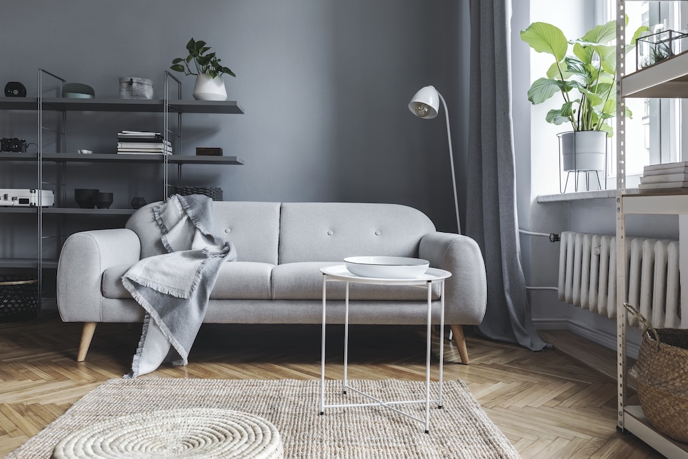 salon w szarościach z sofą i metalowymi szafkami salon w szarościach z materiałowym dywanem na podłodze